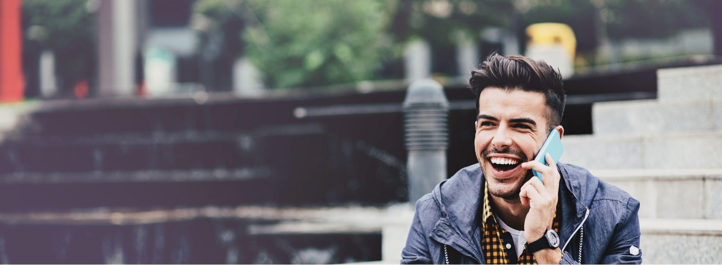 Man smiling while talking on his phone